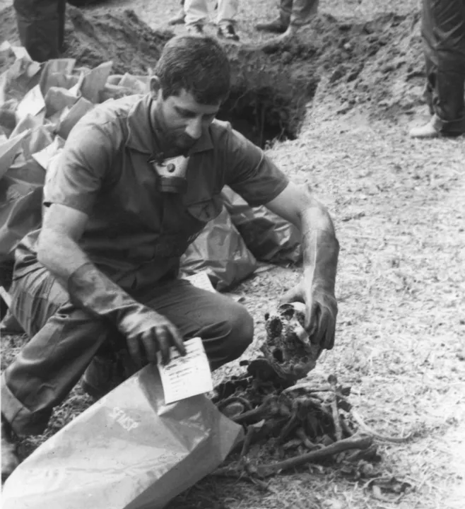 Foto de setembro de 1990 mostra funcionário colocando em sacos plásticos cerca de 1.500 ossadas encontradas em uma vala do cemitério Dom Bosco em Perus, Zona Norte da capital. (Foto: Itamar Miranda/Estadão Conteúdo/Arquivo)