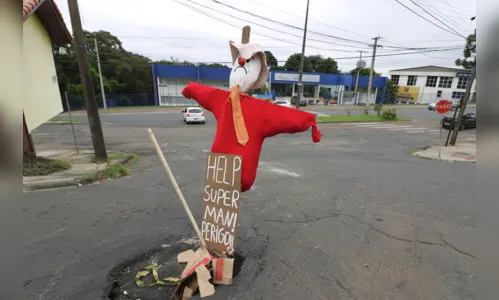 Moradores usam espantalho para sinalizar buraco e pedem ajuda ao 'Superman'