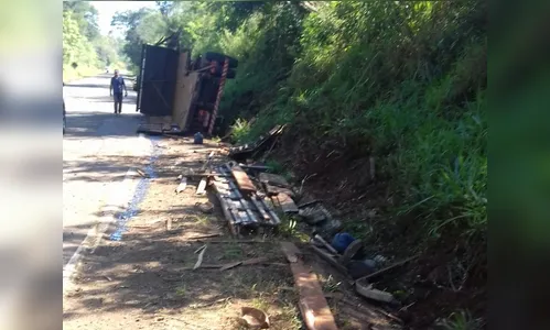 Caminhão carregado com trator tomba na PR-170