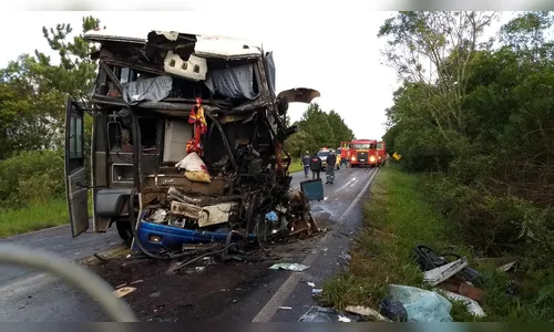 Ônibus e caminhão colidem e motoristas ficam presos nas ferragens