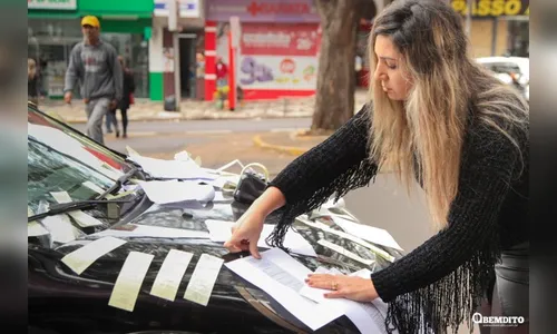 Empresária fica revoltada com multas e cola no carro dezenas de notificações de trânsito