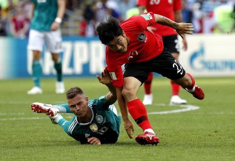 (Joshua Kimmich e Go Yo-han disputam lance e vão ao chão em partida dominada pela Alemanha, mas vencida pela Coreia (SERGEY DOLZHENKO / EFE/ Direitos Reservados)