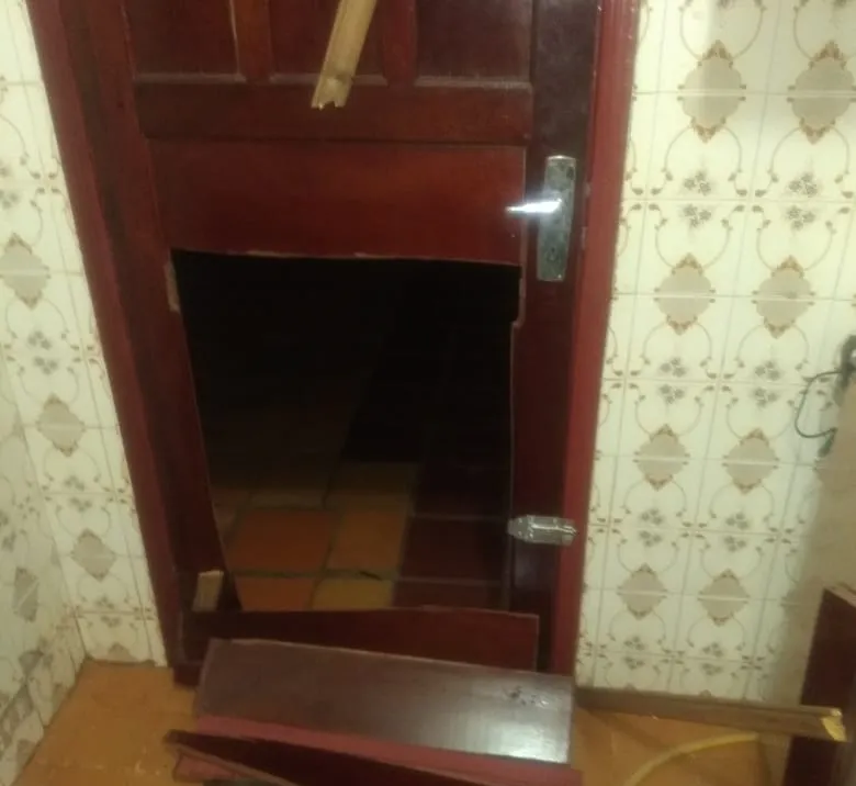 Na residência os bandidos quebraram parte do muro nos fundos da casa e fizeram um buraco na porta de madeira da cozinha. (Foto: Canal HP)