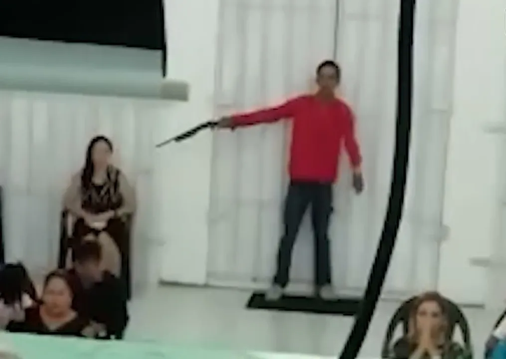 Homem aponta arma para cabeça de mulher durante culto em Manaus — Foto: Reprodução