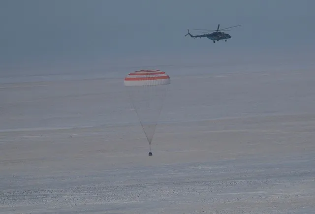 O módulo espacial Soyuz MS-13 aterrissando nesta quinta-feira (6) no Cazaquistão — Foto: Sergei Ilnitsky/Pool via Reuters