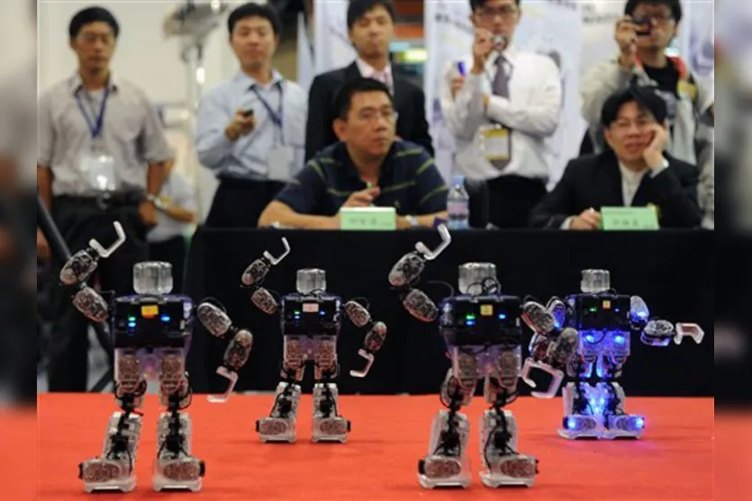   Jurados avaliam o concurso de dança de robôs durante a feira. 