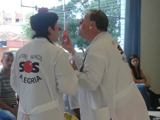 Os 'doutores palhaços' interagem com pacientes que estão na fila para serem atendidos (Foto: Gizele Silva/G1 PR)