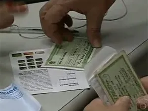 Eleitor com título durante atendimento em cartório (Foto: Reprodução / TV Globo)