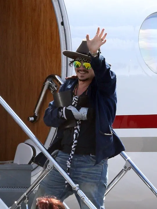 Johnny Depp acena para fãs e para a imprensa antes de embarcar - Fonte da imagem:  ego.globo.com