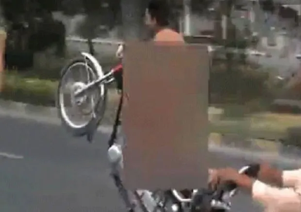 Motociclista nu foi preso ao ser flagrado em avenida movimentada no Paquistão (Foto: Reprodução/YouTube/Breaking News)