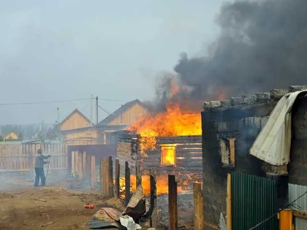 Um homem tenta salvar sua casa do fogo na aldeia de Smolenka. (Foto: Evgeny Yepanchintcev / AP Photo)