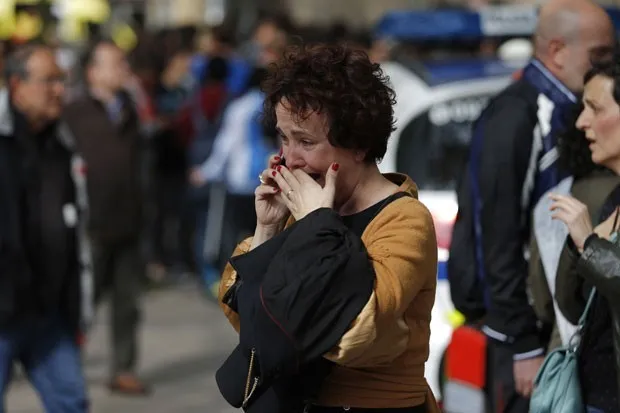 Mulher chora ao telefone após saber de ataque em escola em Barcelona; um professor morreu e quarto pessoas ficaram feridas nesta segunda-feira (20) (Foto: Emilio Morenatti/AP)