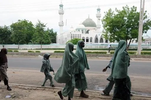 Estudantes muçulmanas passam em frente à mesquita de Maiduguri, capital do estado de Borno, na Nigéria, em julho de 2010 - Foto de Pius Utomi Ekpei/AFP/Arquivos