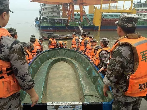 Equipes carregam um barco para resgate (Foto: Chen Zhuo / Reuters)