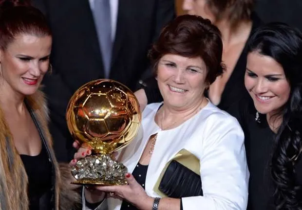 Dolores Aveiro (ao centro) segura a última Bola de Ouro conquistada pelo filho