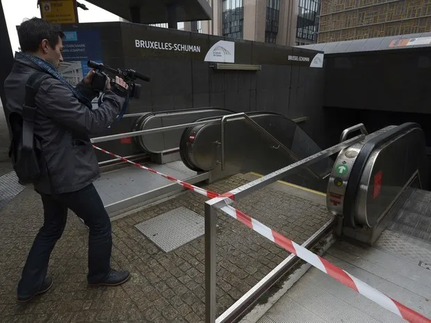 Uma pessoa filma uma entrada fechada da estação Shuman Railways, em Bruxelas, neste sábado (21). Todas as estações de metrô em Bruxelas ficarão fechadas hoje (Foto: AFP PHOTO/JOHN THYS)