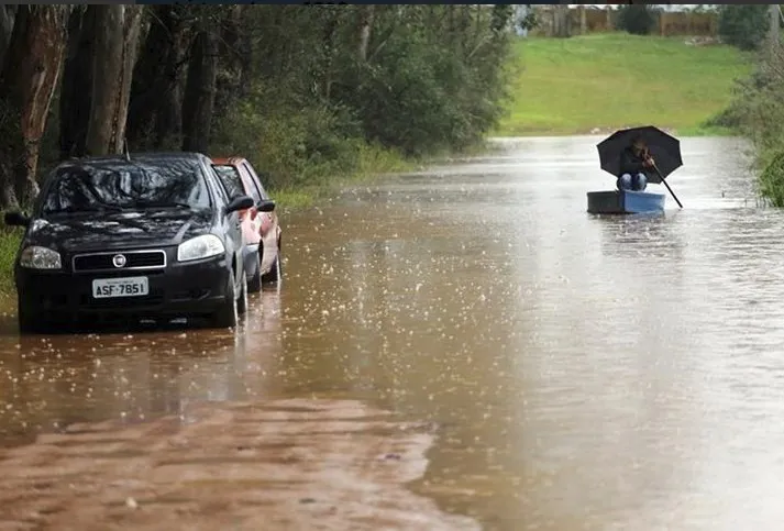 Morador usa bote para se deslocar durante a chuva no Paraná - Foto: a Rede.info