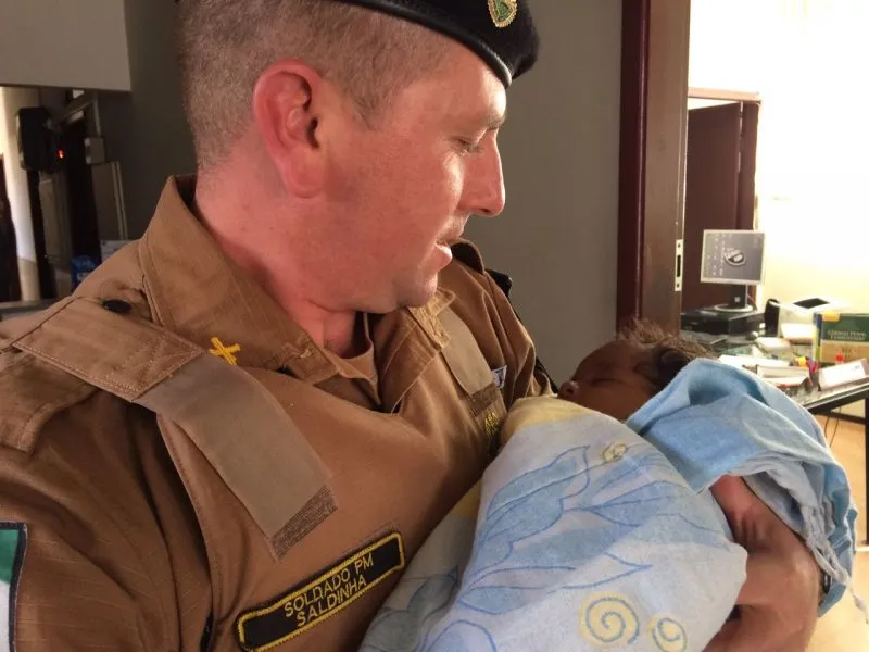 Soldado Saldinha e o bebê resgatado às margens da Rodovia da Uva. Foto: DM/Banda B