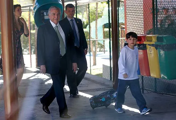 Presidente busca seu filho com Marcela, na escola. (Foto: Reprodução / Folha de São Paulo)