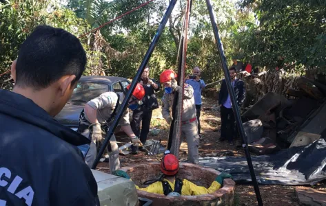 Bombeiro desce em poço para retirar corpo de moça assassinada por traficantes - Foto: Fernanda Neme