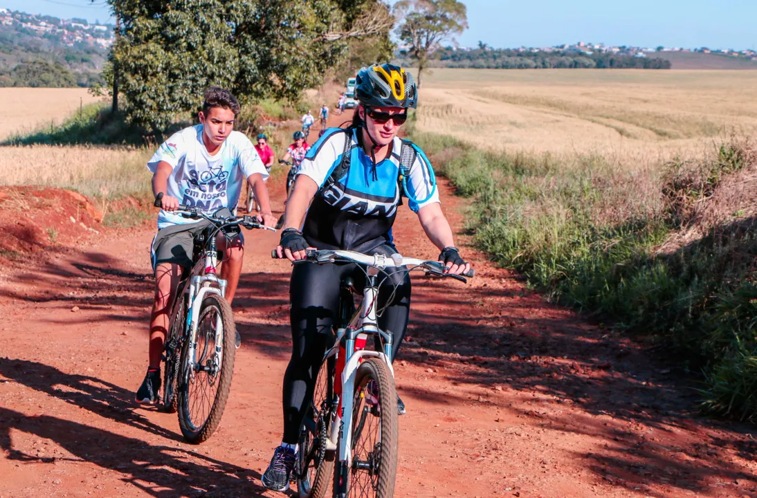 Ciclistas pedalam por estradas rurais no desafio de bike